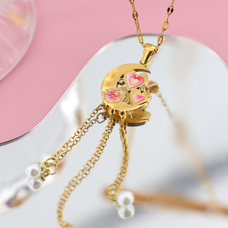 Hand-Painted Enamel Moon Necklace | Artisanal Heart Jewelry Close-up of pink enamel hearts and a rose on a 18k gold plated moon pendant, artistic jewelry photography.